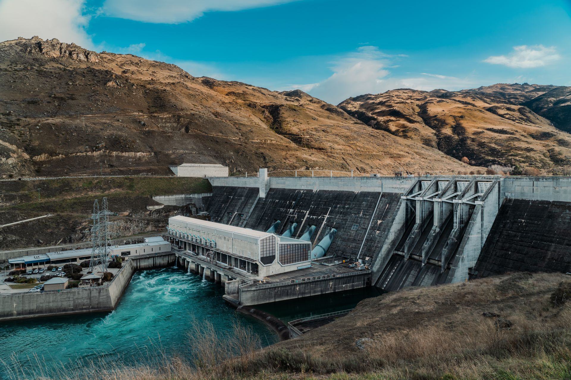 Hydroelectric dam and power station in a mountain valley, with its switchyard and outflow channel