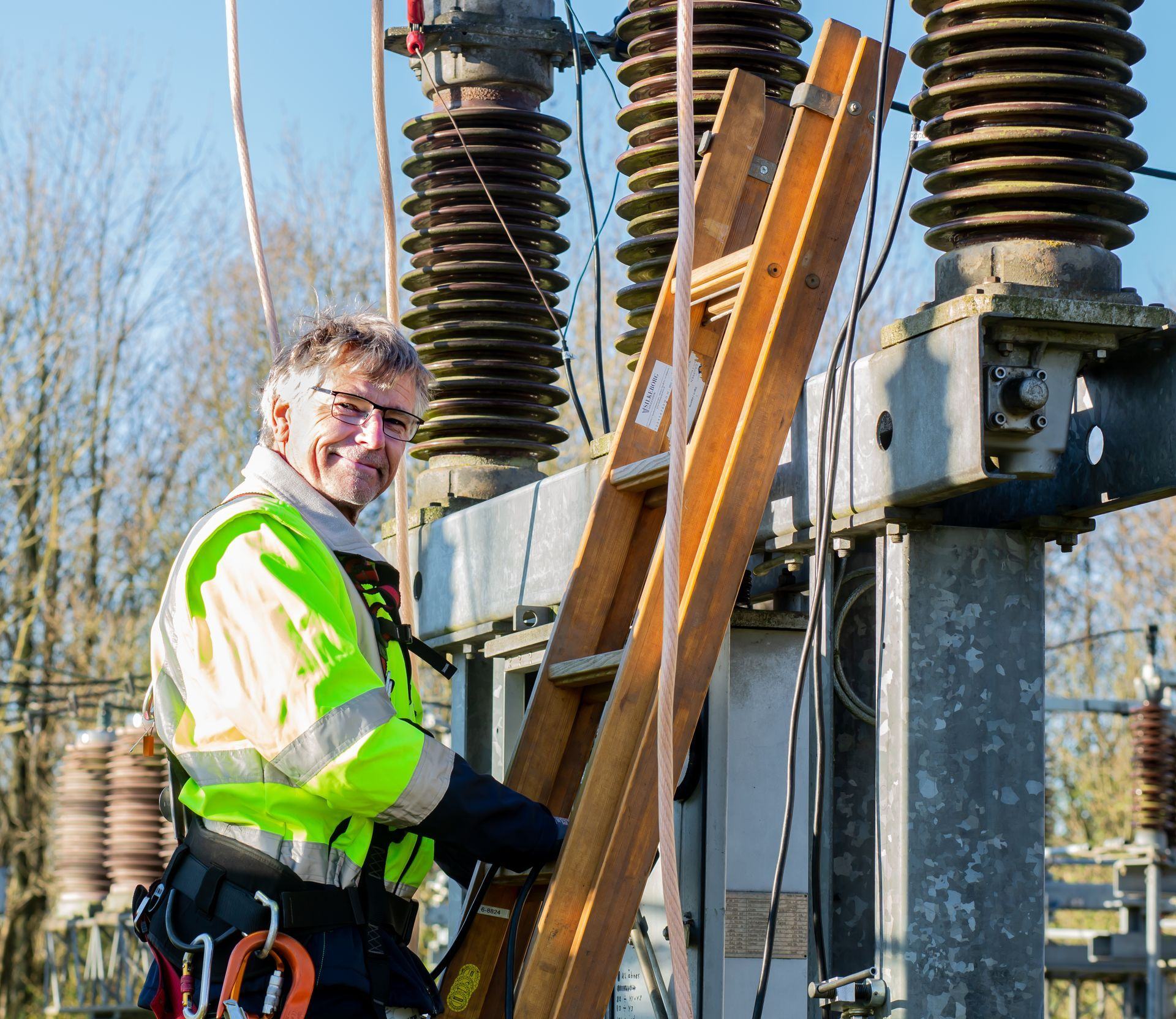 Engineer in a high-visibility jacket at work on substation equipment