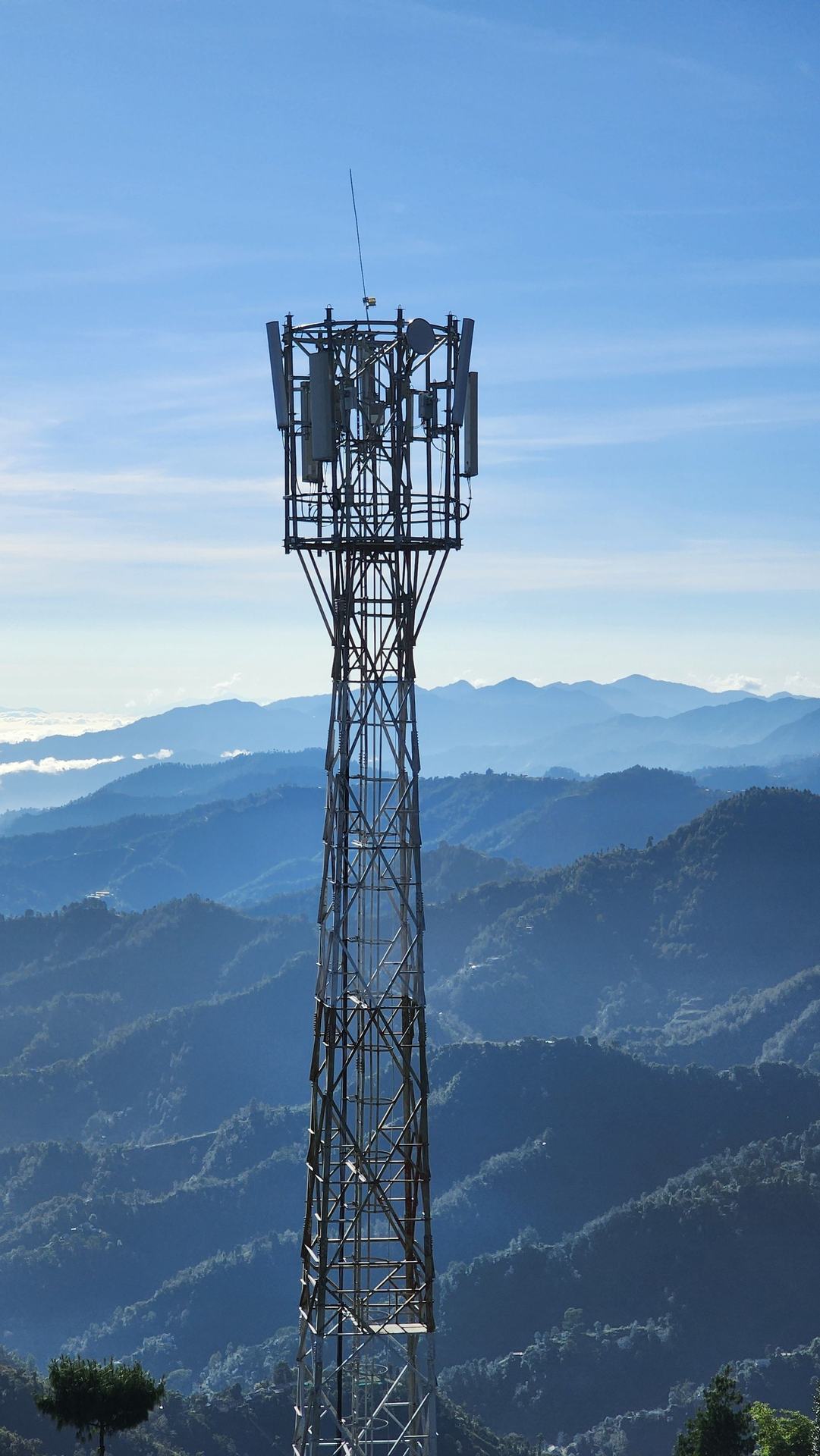 Lattice telecoms tower on a ridge above mountain valleys